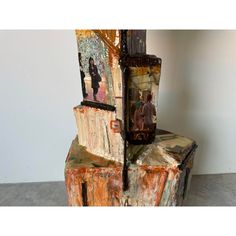 an artistic sculpture made out of wood with pictures on it