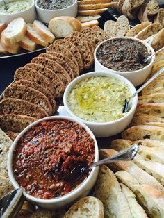 breads and dips are arranged on a table