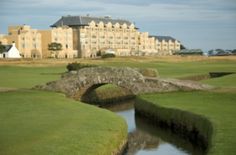 a golf course with a bridge and building in the background