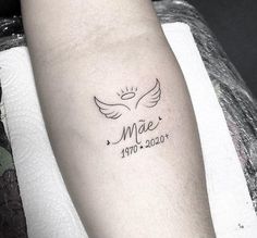 a small tattoo on the arm that reads mae and has two white doves in it