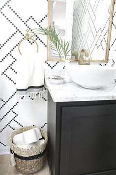 a bathroom with black and white wallpaper, a sink and mirror in the corner