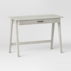 a white desk with a drawer on the top and legs, in front of a gray background