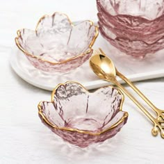 three glass bowls with gold handles and spoons