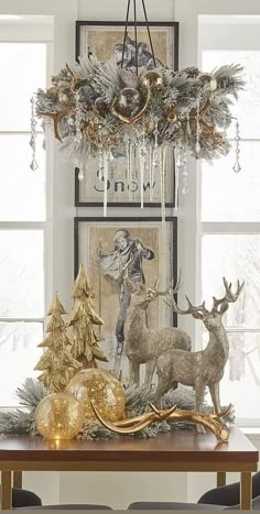 a dining room table decorated for christmas with gold ornaments and deer figurines on it