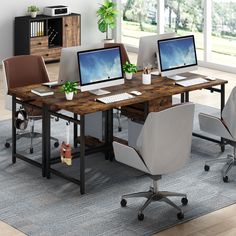 an office desk with three computers on it and two chairs in front of the desk