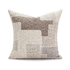 a white and brown pillow with squares on it's side, against a white background