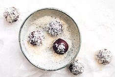 a bowl filled with chocolate truffles covered in powdered sugar