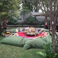 a large green bean bag sitting on top of a lush green field next to trees