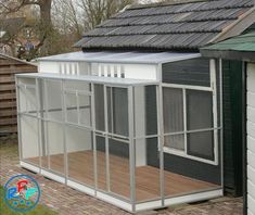 a chicken coop in the back yard with a roof on it's top floor