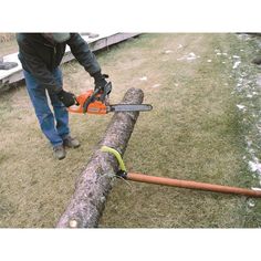 a man using a chainsaw to cut a log