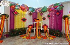 an outdoor stage decorated with bright colors and decorations for a wedding or special event in india