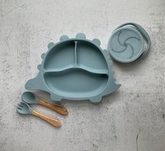 a set of blue dishes with wooden spoons and utensils on a concrete surface