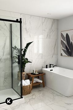 a bathroom with marble walls and flooring next to a bathtub, shower stall and sink