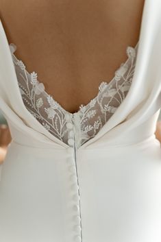 the back of a woman's white wedding dress