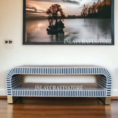 a bench sitting in front of a painting on the wall