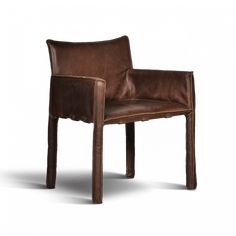 a brown leather chair sitting on top of a white floor