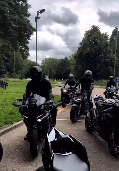 a group of motorcyclists are parked on the side of the road together