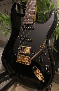 a black electric guitar sitting on top of a table