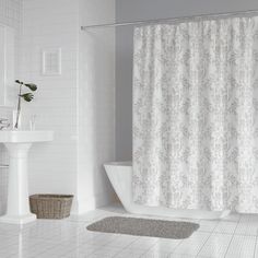 a bath room with a sink and a shower curtain on the side of the tub