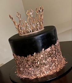 a black and gold cake with a crown on top