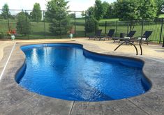 an empty swimming pool with chairs around it