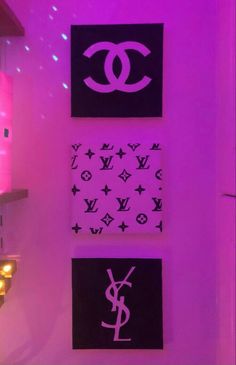 three chanel wall hangings in a room with purple lighting and lights behind them