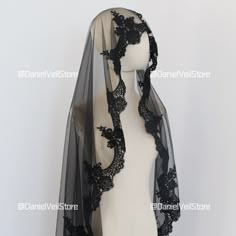 a black lace veil on top of a mannequin