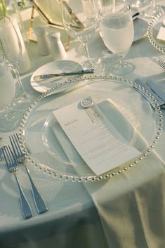 the table is set with silverware and place settings