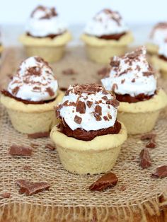 chocolate cupcakes with whipped cream and chocolate chips on a burlap cloth