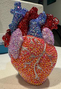 a vase filled with lots of different colored stones on top of a white countertop