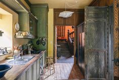 an old kitchen with wooden floors and green painted walls is pictured in this image from the doorway