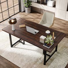 a wooden table with a laptop on top of it in a living room next to a potted plant