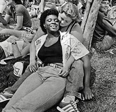 black and white photograph of people sitting on the grass