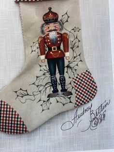 a christmas stocking with an image of a nutcracker hanging from it's side