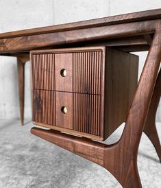 a wooden desk with three drawers on it