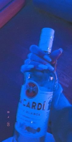 a bottle of cardi water sitting on top of someone's lap with their hand wrapped around it