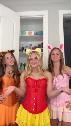 three girls dressed up in costumes posing for the camera