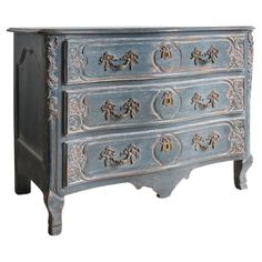 an old blue dresser with ornate carvings and knobs on the drawers is isolated against a white background