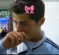 a man with a pink bow on his head is looking at something in front of him