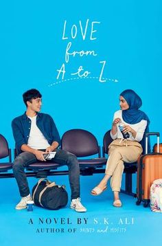 a man and woman sitting next to each other on a bench in front of a blue wall