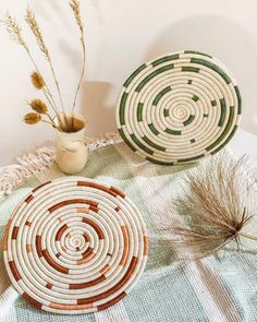 two baskets sitting on top of a table next to a vase filled with dried plants