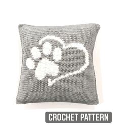 a crochet pillow with a dog's paw and heart on the front