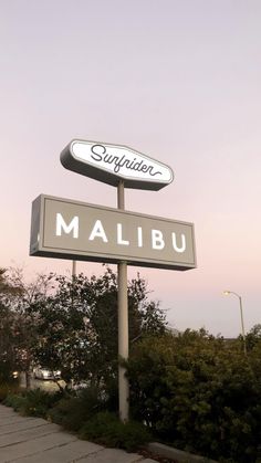 there is a sign that says sushitera and malubu in front of some bushes