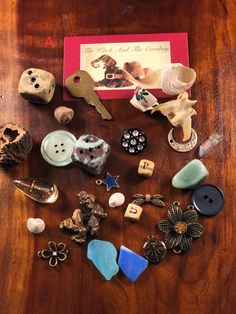 a wooden table topped with lots of different types of buttons and brooches on top of it