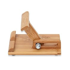 a wooden cutting board with a knife on it's side and a metal object in the middle