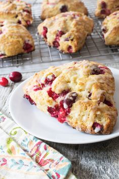 cranberry scones on a white plate next to a cooling rack