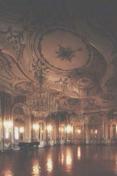 an ornate room with chandeliers and mirrors on the ceiling is lit by candles