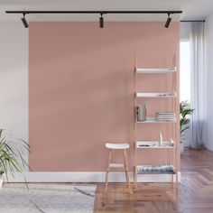 a living room with pink walls and white furniture in the corner, along with a plant