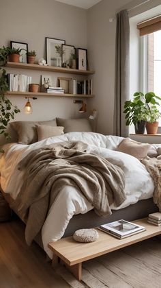 a bed with blankets and pillows on top of it in a bedroom next to a window