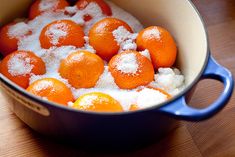 oranges and sugar in a blue pot on a wooden table